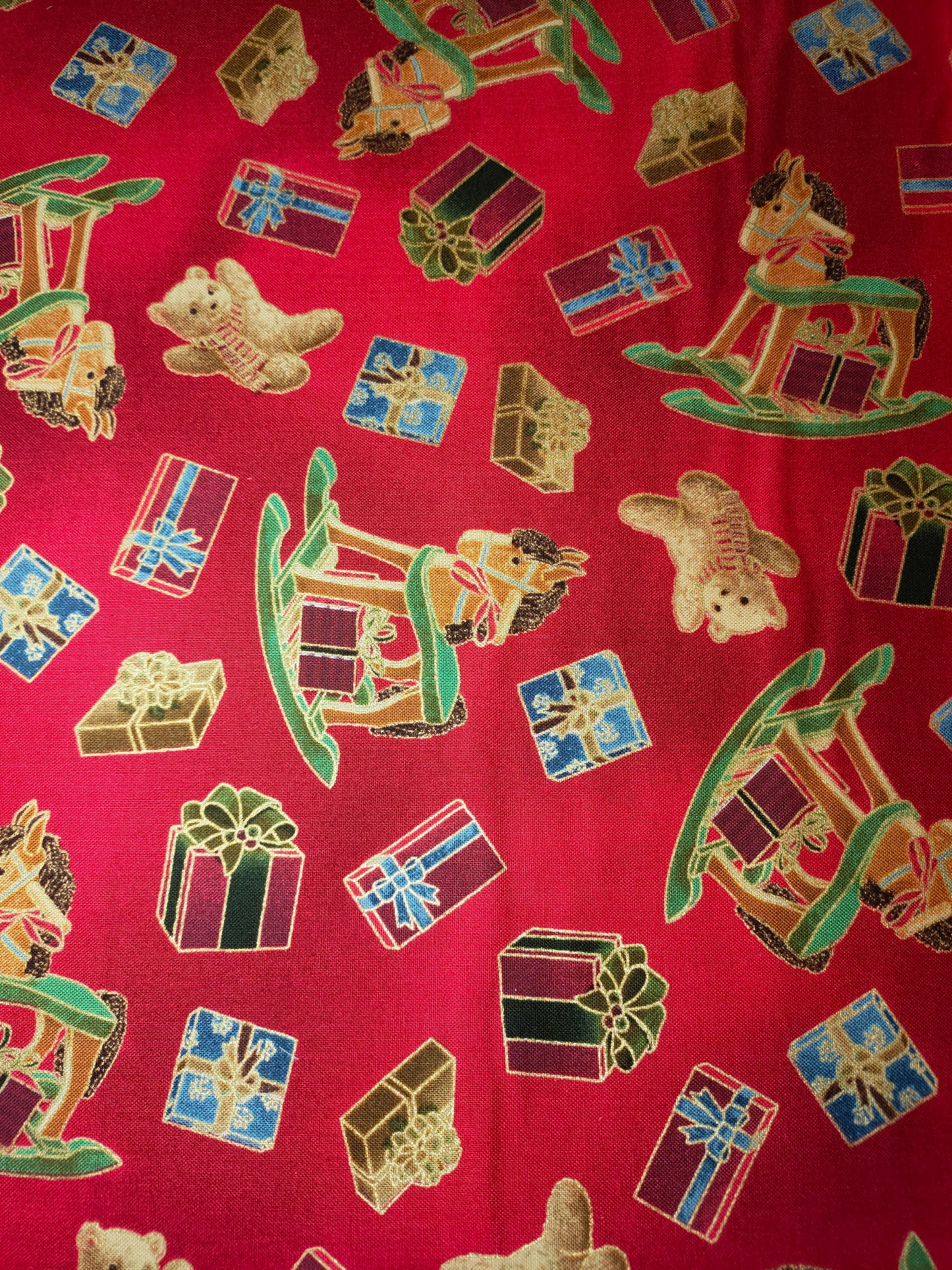 VIP Premium 100% cotton fabric.  Fat Quarter.  Christmas presents, teddies and hobby horses with gold outlines on a red background.