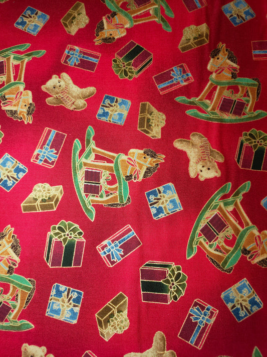 VIP Premium 100% cotton fabric.  Fat Quarter.  Christmas presents, teddies and hobby horses with gold outlines on a red background.