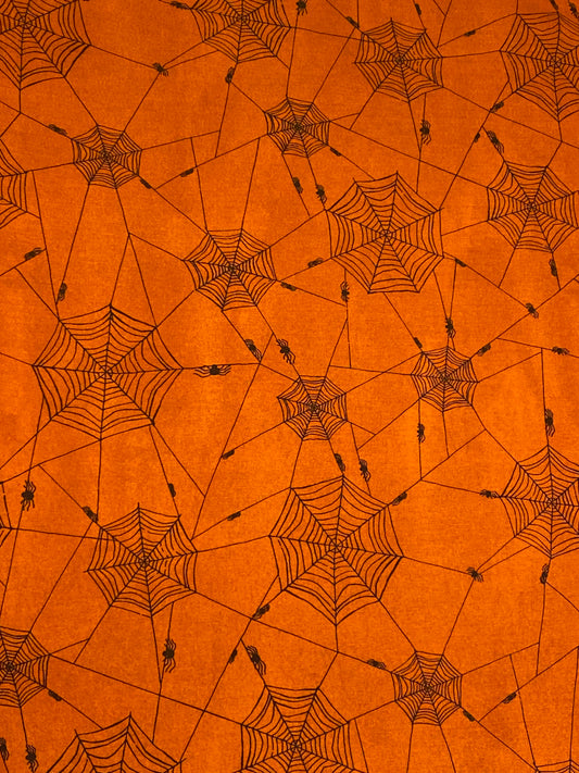 Studio e Witchy 100% cotton fabric. Fat Quarter.  Black cobwebs and spiders on an orange background.